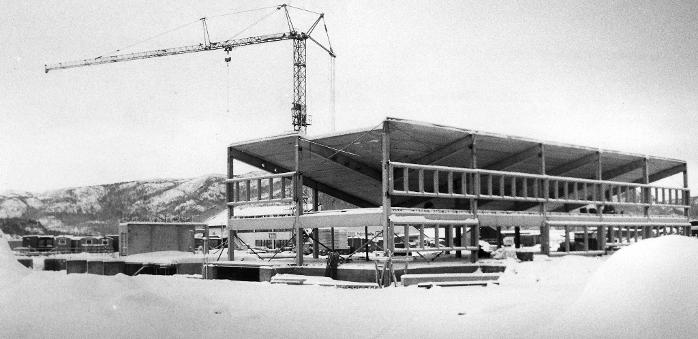 Bygging av Kulturhuset i Namsos. Bildet tatt utendørs på vinteren og viser "skallet" av bygget. En kran løfter på plass elementer