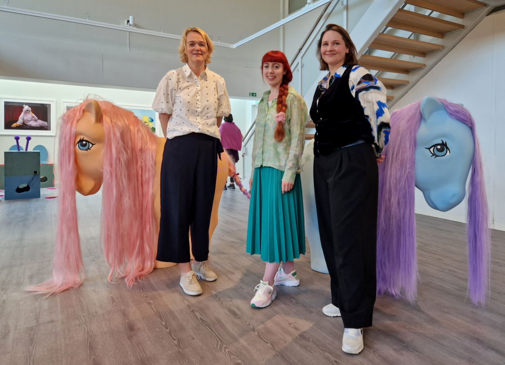 Kunstner Anja Carr, museumsleder Sara Cornelia Greiff og leder Hovedutvalg for Kultur i Trøndelag fylkeskommune, Bente Estil foran to skulpturer av My Little Pony